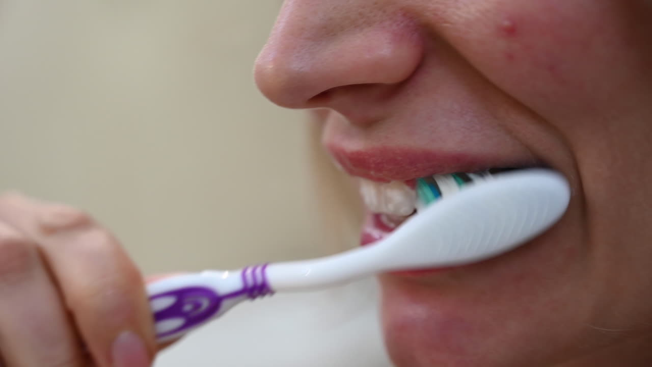Close up of a woman brushing her teeth in the morning