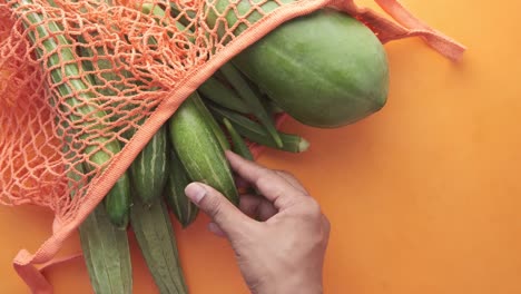 verduras frescas en una bolsa de malla naranja