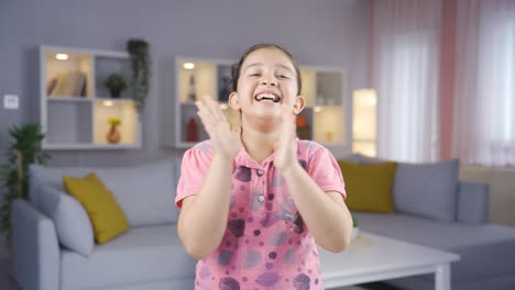 Girl-child-clapping-excitedly-to-camera.