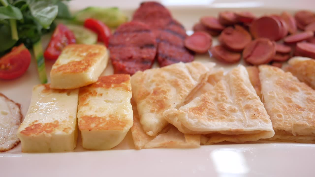Colazione turca con salsiccia, formaggio, pane, uovo, pomodoro e cetriolo.