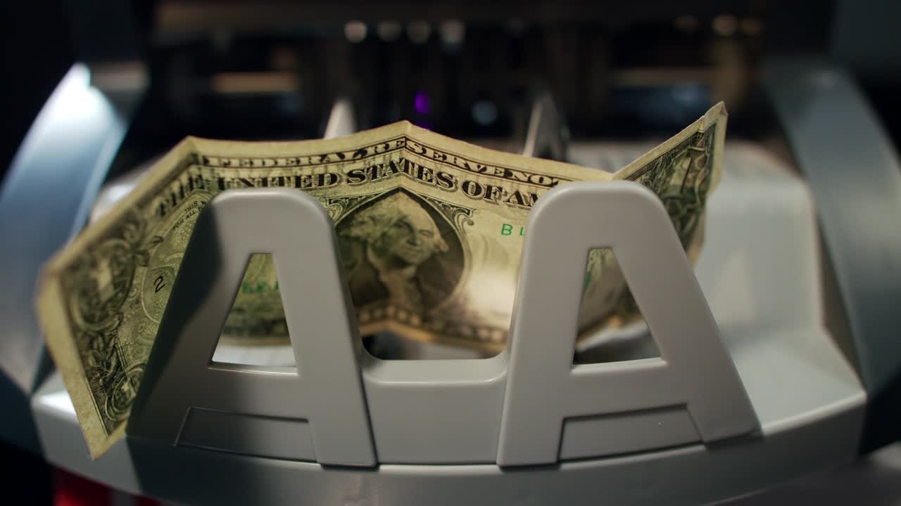 Banconota da un dollaro in macchina contabanconote. Concetto di crisi finanziaria.