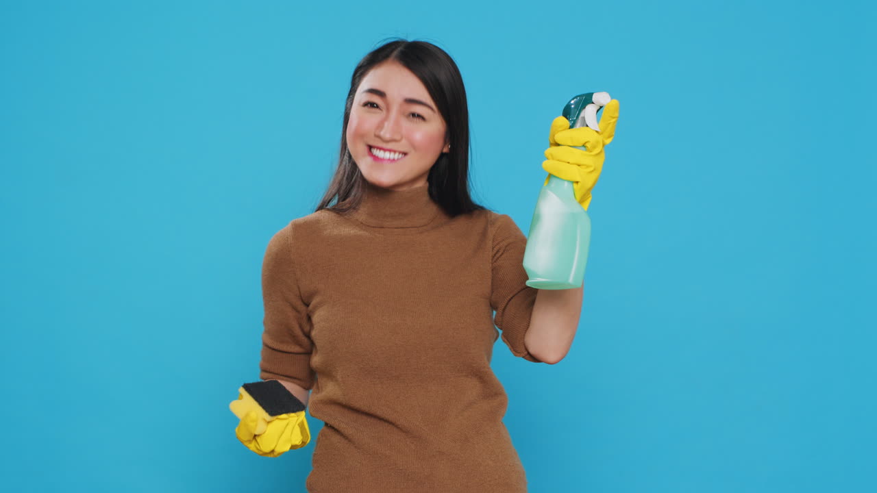 Professional housekeeper being amazed about how good is detergent spray while cleaning house