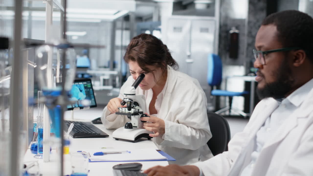 Vertical video Clinical lab technologist uses scientific microscope for disease detection