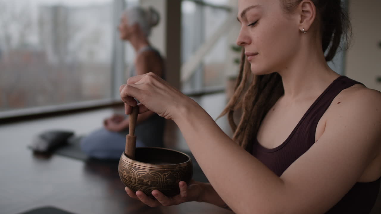 Woman meditating with singing bowl, promoting inner peace and well-being