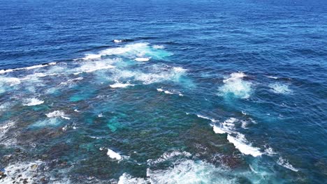 ocean waves breaking over volcanic rock formations