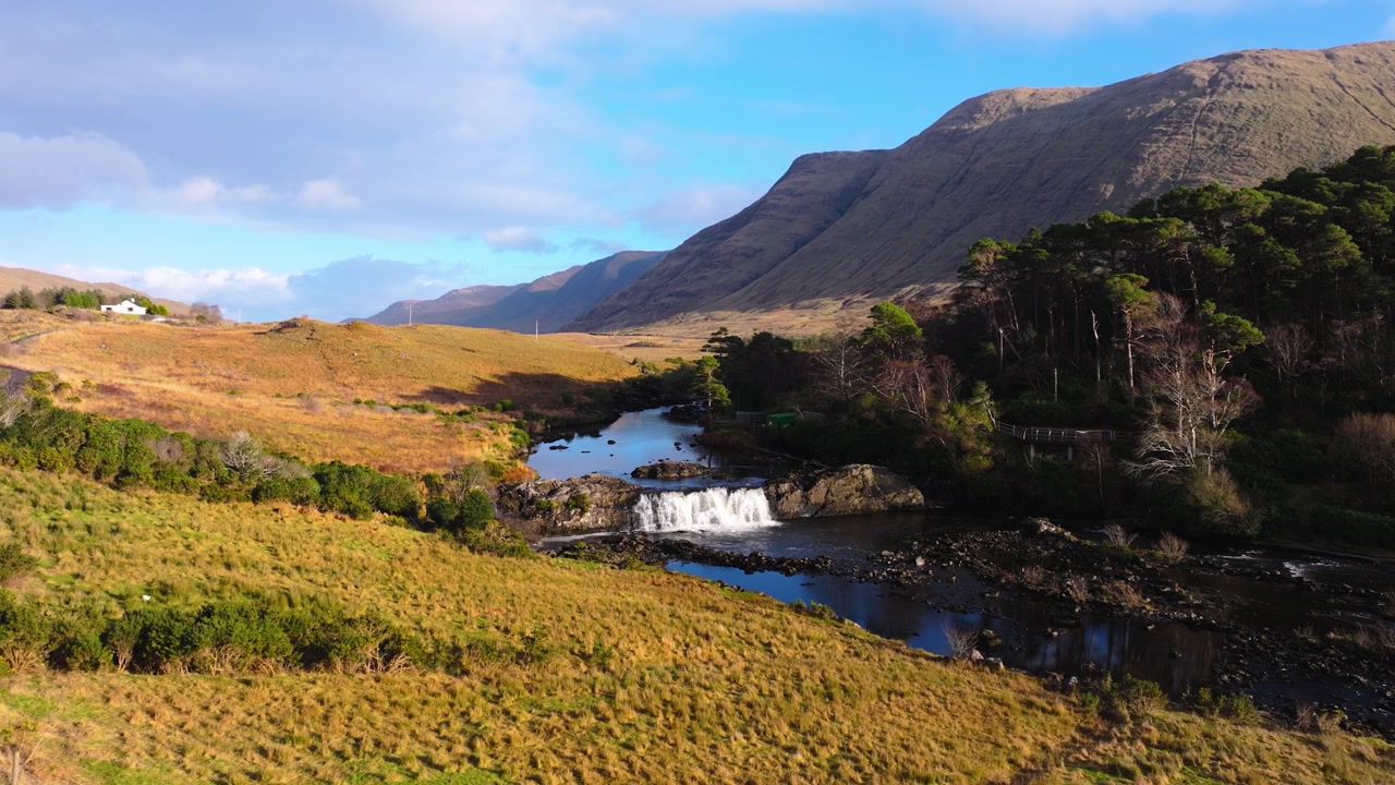 4K Aerial view of Aasleagh Falls highlighting a small waterfall along a river in a remote natural setting. Captures the movement of water and surround._08