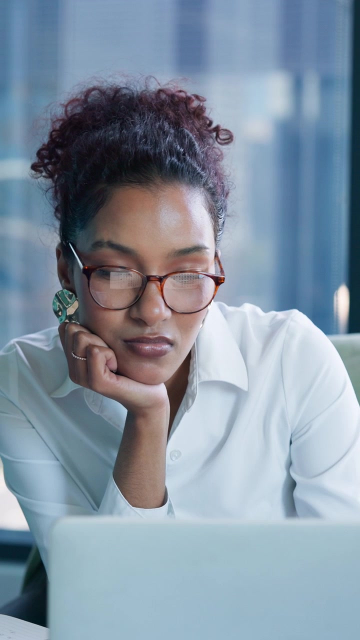 Focused Professional Woman Working on Laptop in Office