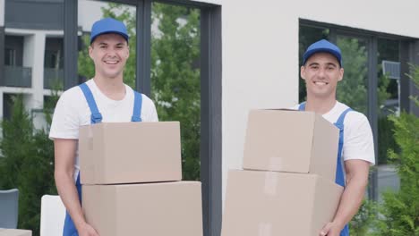 two young workers of removal company deliver boxes to a customer's home