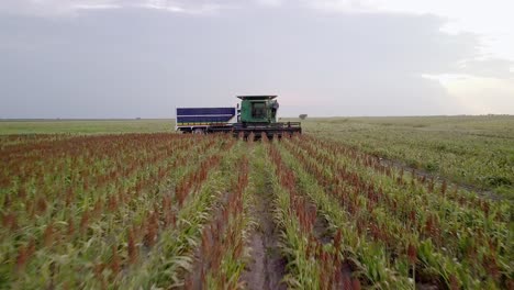 AERIAL---Thresher,-or-threshing-machine,-on-a-farm-field,-wide-shot-forward