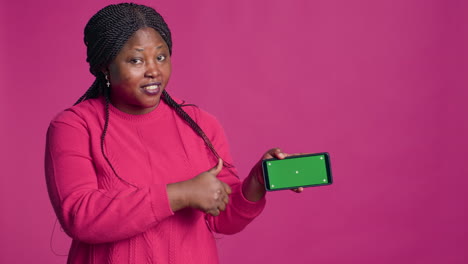woman grasping phone with green screen