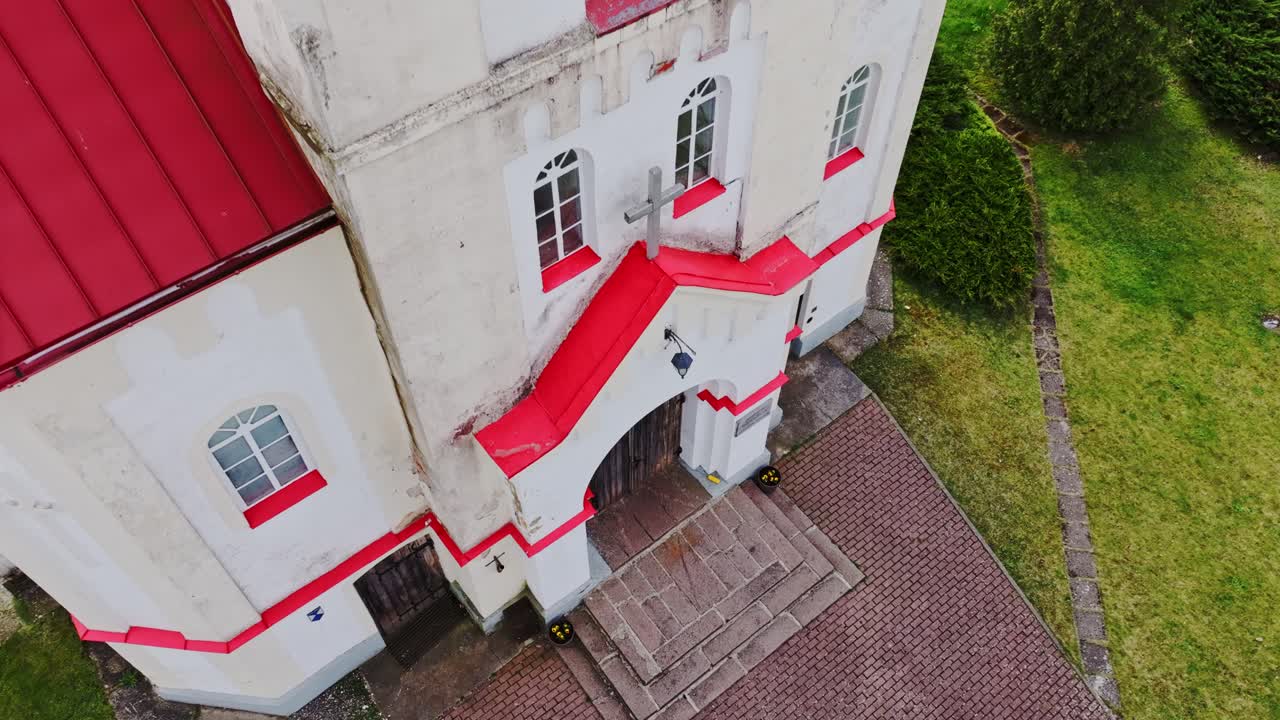 Striking red rooftop, steeple of Rucava Lutheran Church seen from above, Latvia