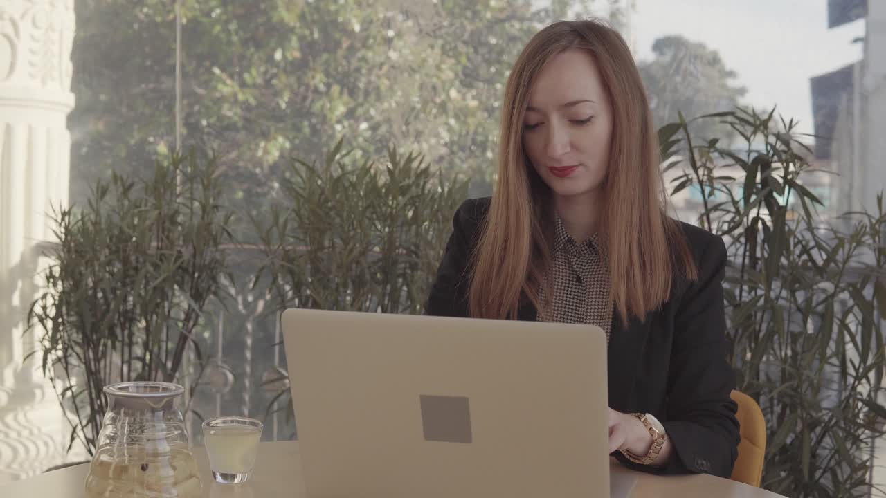 Donna che lavora al computer portatile in un caffè