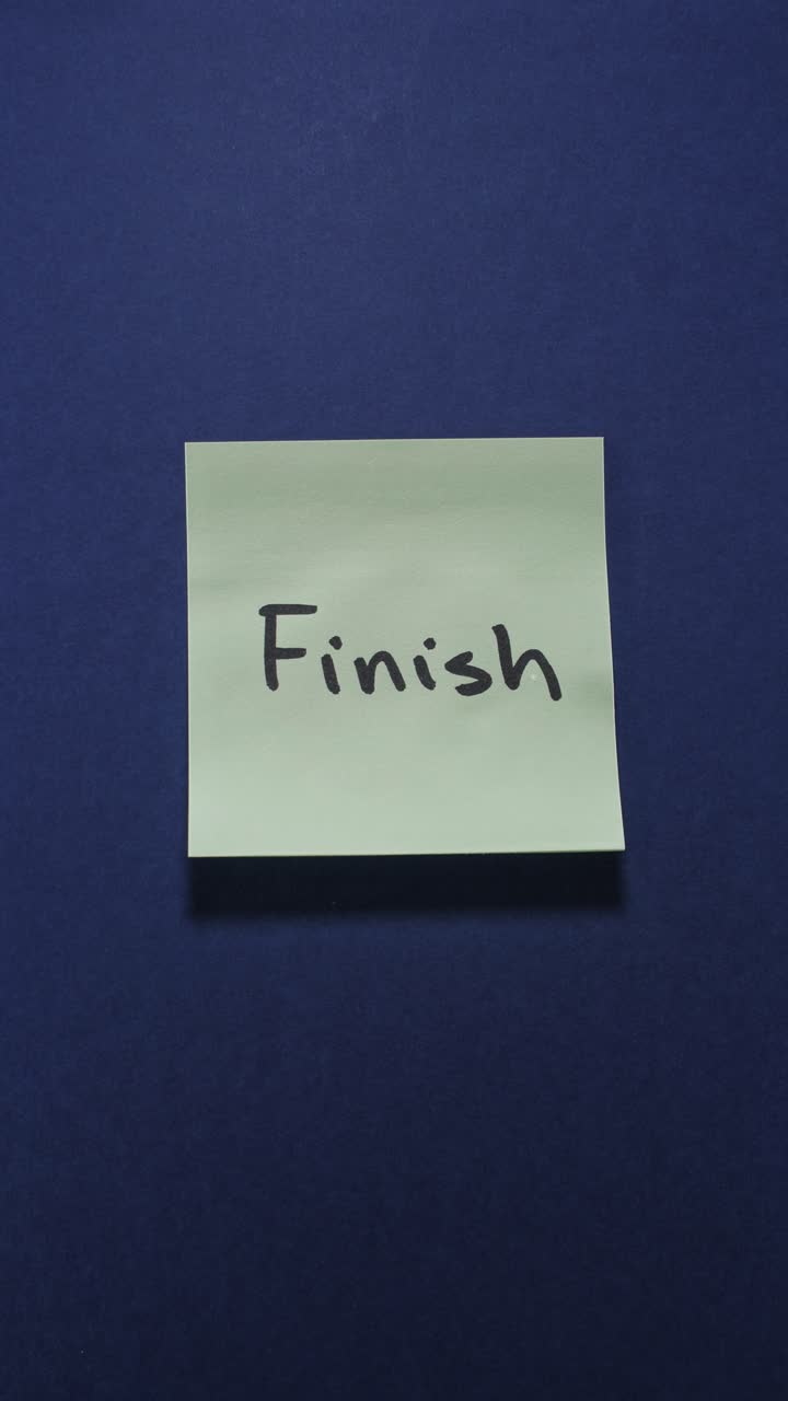 Portrait shot of a light green sticky note reading "Finish" on a dark blue background