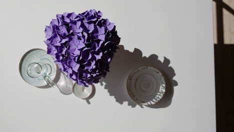overhead still life of purple hydrangeas and tableware with shadows