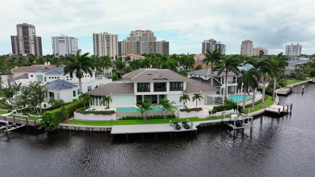 Drone footage capturing luxurious waterfront mansions in a coastal South Florida community