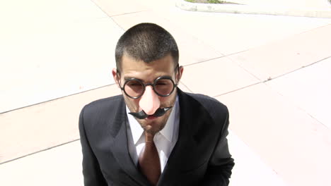 a businessman smokes a cigar wearing a groucho marx style face mask