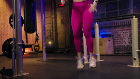 woman doing a jump lunge exercise in the gym. - wide shot