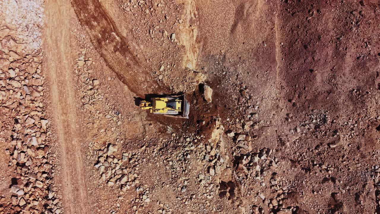 Heavy machinery clears rocky terrain in construction site