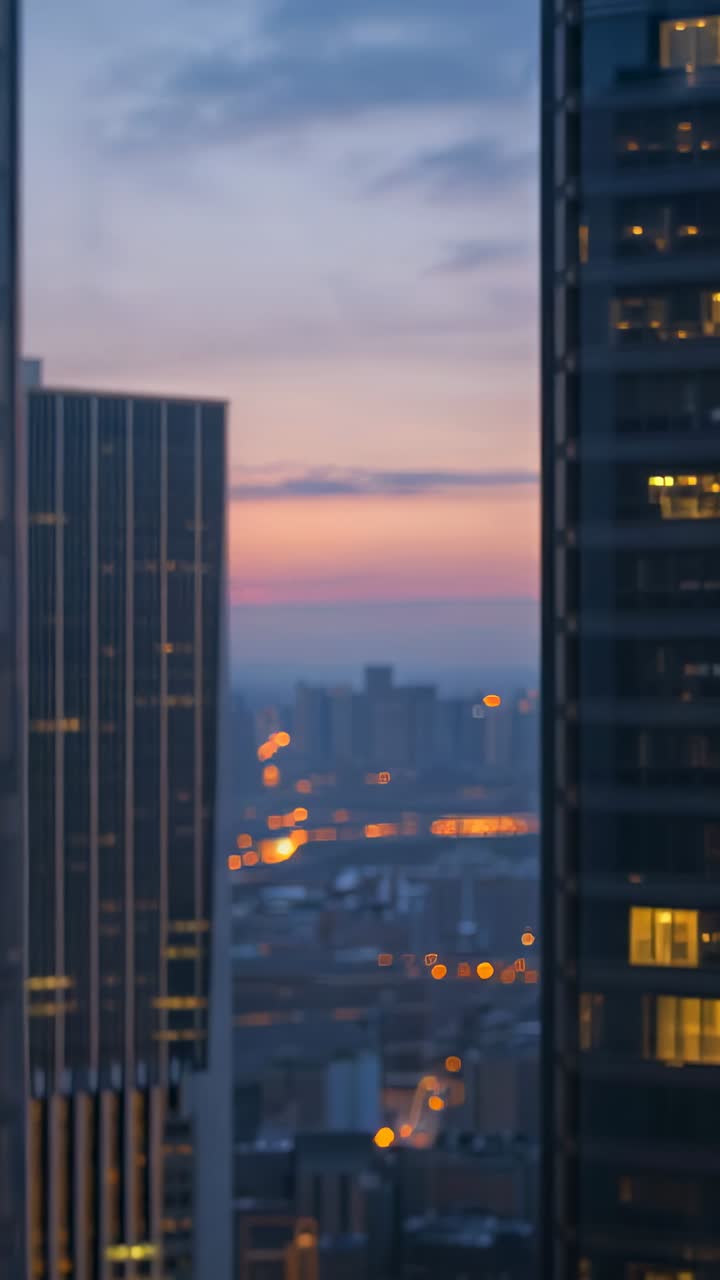 Vertical video: Fading sunset revealing skyline through office tower gap, with windows lighting up