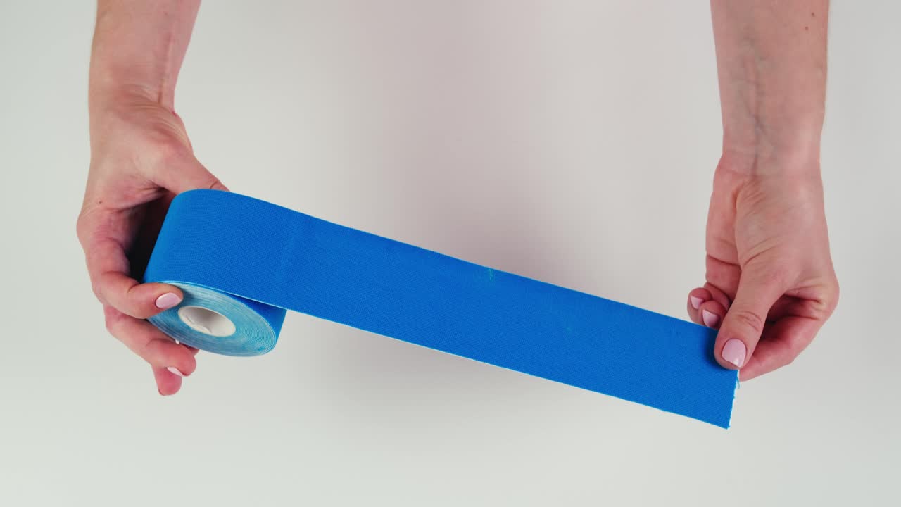 Kinesiology medical taping, doctor Physical therapist applying elastic surgical tape to patient body, treating injured knee young athlete.Post traumatic rehabilitation, sport physical therapy recovery