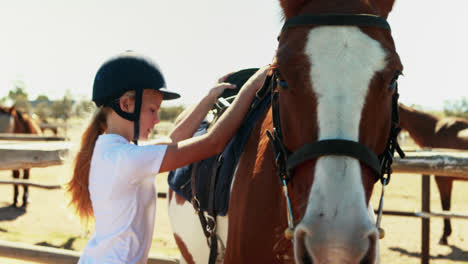 Girl-tightening-horse-saddle-for-horseback-riding-4k