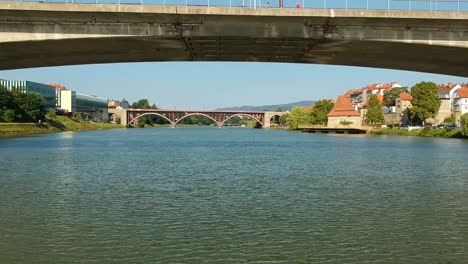 dlying a drone under the bridge across river drava in maribor, slovenia