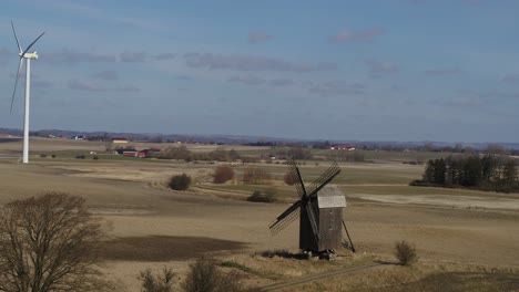 antiguo molino de viento de madera y nuevas turbinas de viento - vuelo de drones