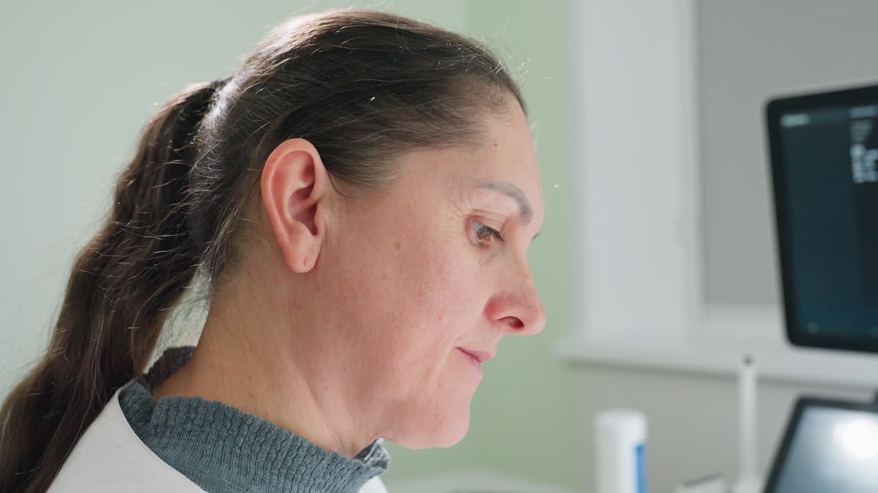 Close up of professional medical practitioner focusing eyes on diagnostic equipment with intense concentration during examination procedure inside clinical room showcasing precision and attentiveness