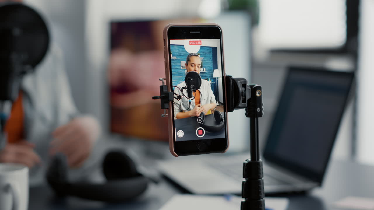 Social media famous influencer recording video blog with modern smartphone while speaking to audience