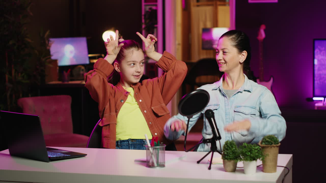Mamma che impara una coreografia di tendenza dalla figlia influencer in un appartamento illuminato da neon rosa.