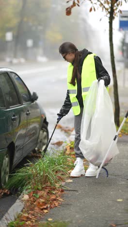 mujer limpiando la basura en la calle