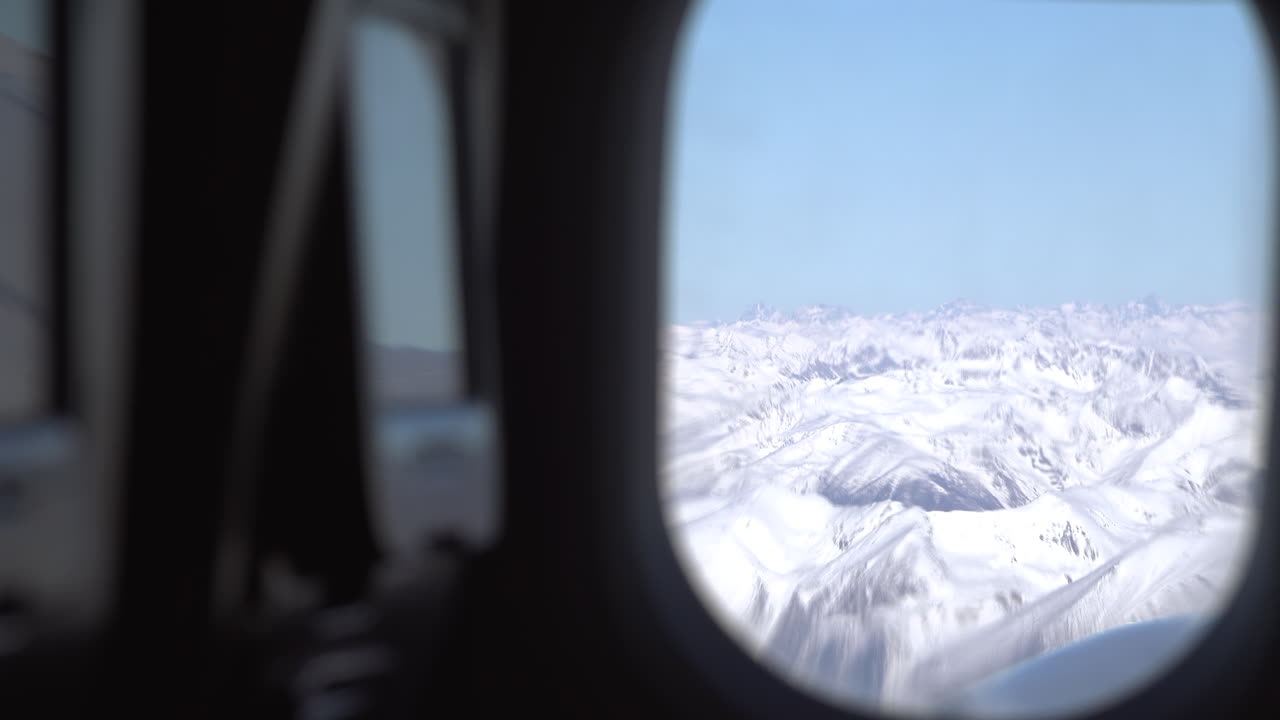 View from an airplane window of the snowed mountains