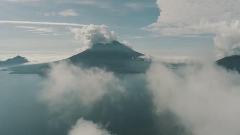 Drone-aerial-flying-high-over-the-clouds,-landscape-view-of-beautiful-Lake-Atitlan-and-San-Pedro-Volcano-in-Guatemala