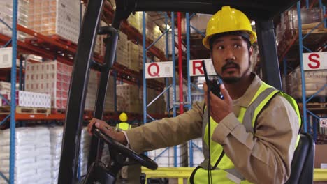Young-man-working-in-a-warehouse-sitting-in-a-forklift-truck-4k