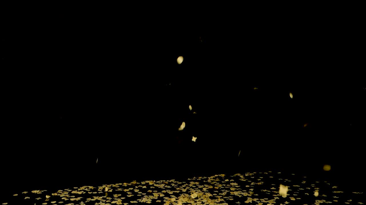 Thousands of confetti pieces fall from above on black table