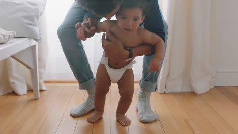 happy baby learning to walk toddler taking first steps with father helping infant teaching child at home