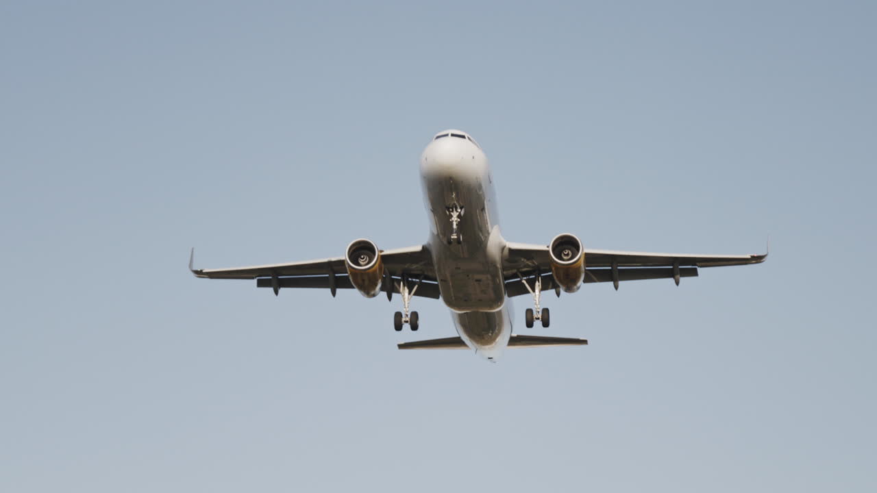 Avión volando en el cielo para aterrizar en el aeropuerto a cámara superlenta al atardecer