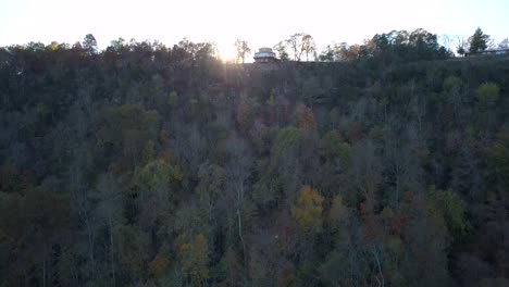 Rising-shot-of-fall-foliage-on-river-bank-revealing-sunshine