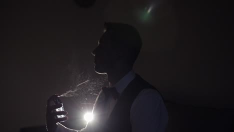 el novio se coloca perfume o desodorante en sí mismo, día de la boda, cámara lenta, hombre de negocios bien vestido