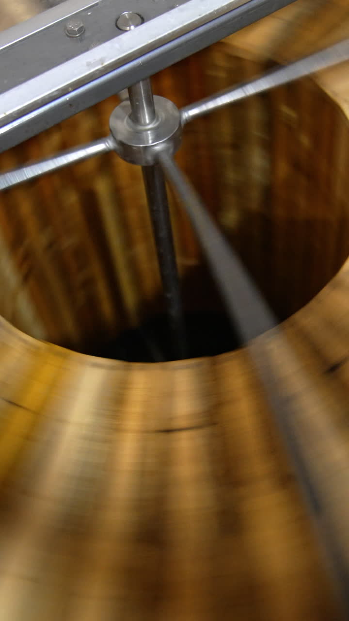 Production of healthy organic honey in the apiary. Honey extracting machine spinning the wooden frames. Top view. Vertical video