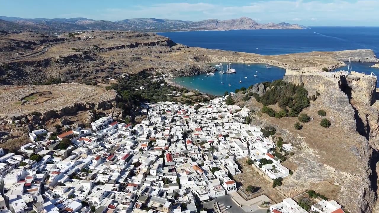 Veduta aerea da drone che mostra un'area di parcheggio curva circondata da strade su terreno roccioso e appartamenti colorati vicino alla Marina di Albufeira in Portogallo, sulla costa dell'Algarve