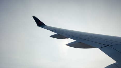 the wing of a plane passes over the sun