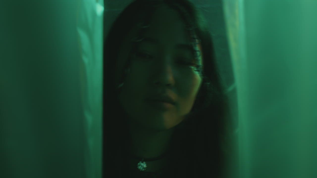 Pretty Asian Woman with Braids Posing in Colorful Neon Light