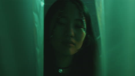 pretty asian woman with braids posing in colorful neon light