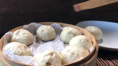 Herausnehmen-Der-Brötchen-Aus-Dem-Dampfkorb-Mit-Einem-Bambusbesteck