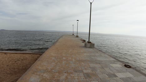 a shot of a seaside pont along a sandy beach on the mediterranean