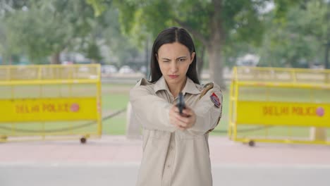 indian female police officer aiming handgun on someone