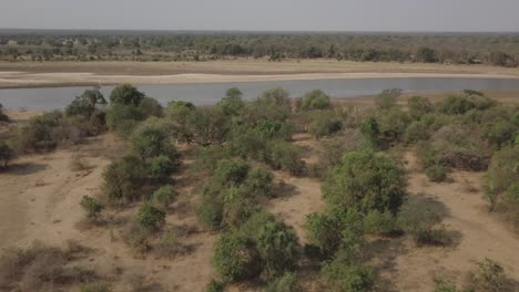 Antena-Baja-Y-Lenta-Al-Río-Lupande-En-Zambia,-Casas-En-La-Orilla-Opuesta