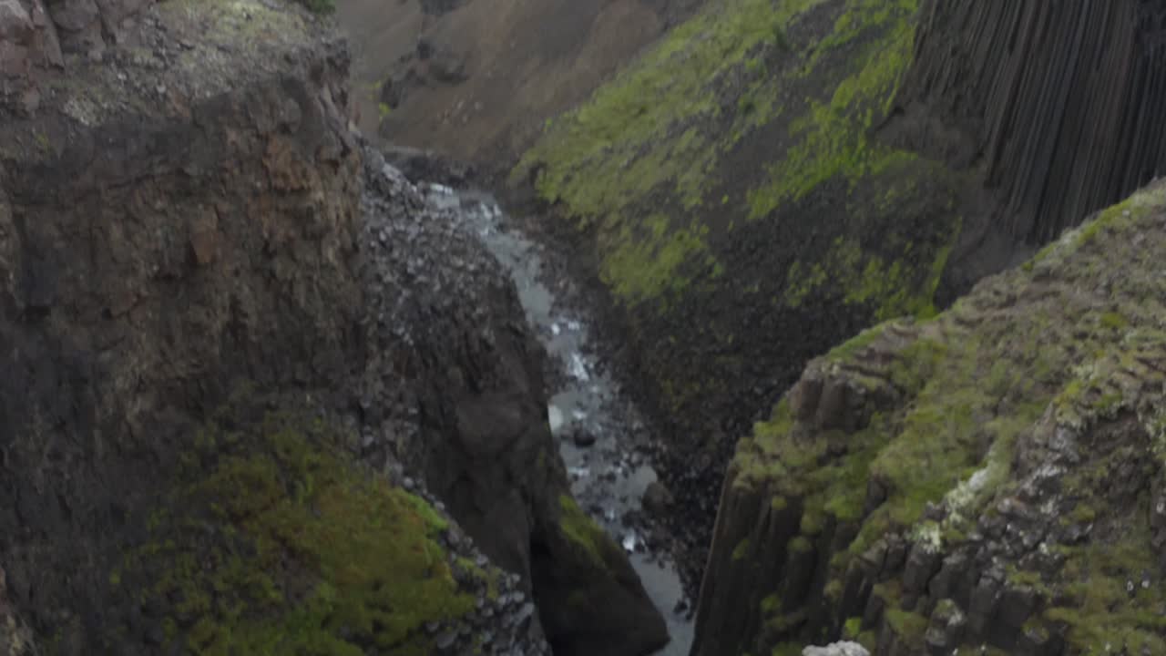 vuelo de avión no tripulado cinematográfico sobre acantilados y cascadas de islandia durante el día - toma de inclinación hacia abajo