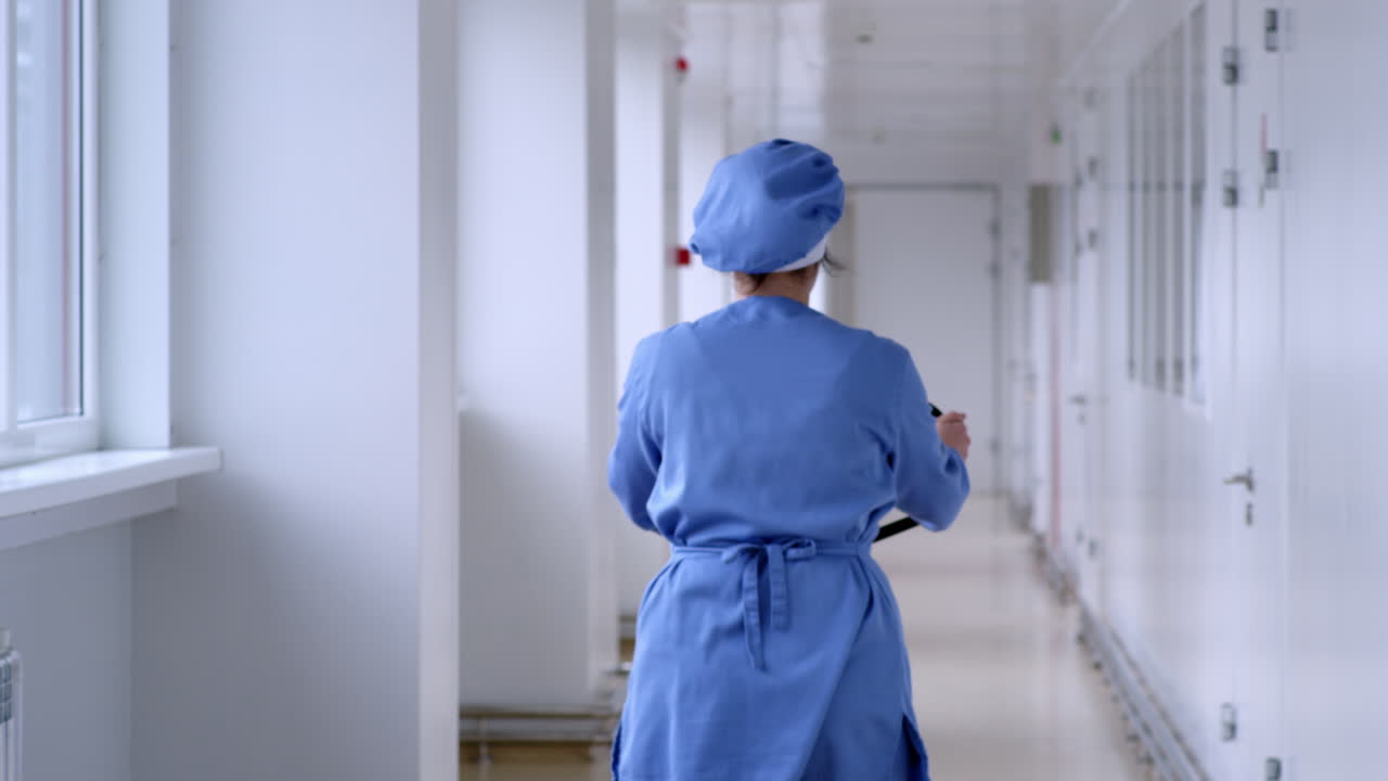 женщина, управляющая подъемником в белом коридоре. работает на складском заводе